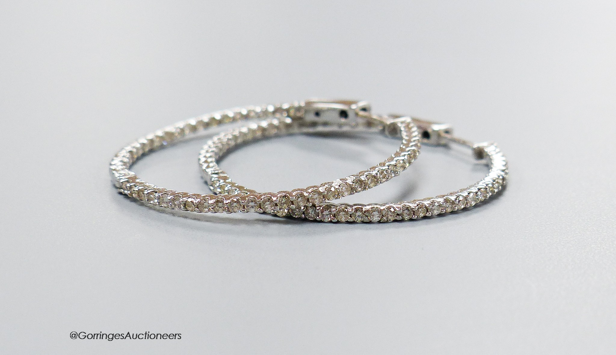 A modern pair of 18ct white gold and diamond chip set hoop earrings, diameter 32mm, gross weight 5.4 grams.